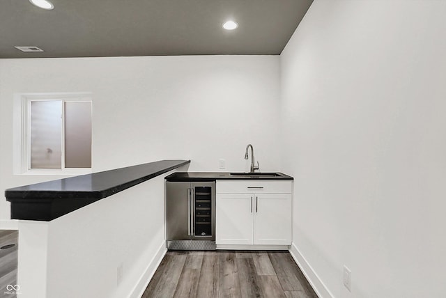 bar with white cabinetry, wood-type flooring, sink, and wine cooler