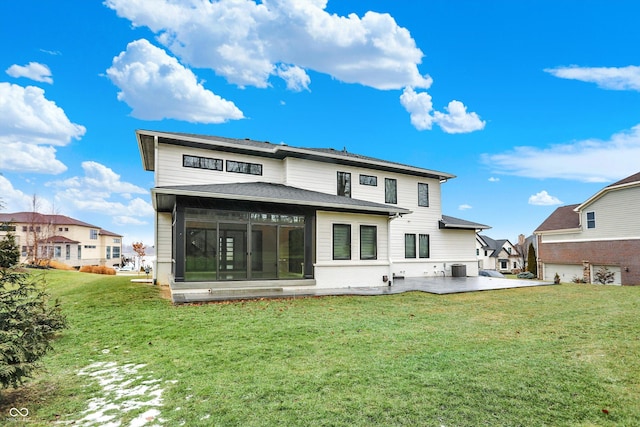 rear view of house with a patio and a lawn