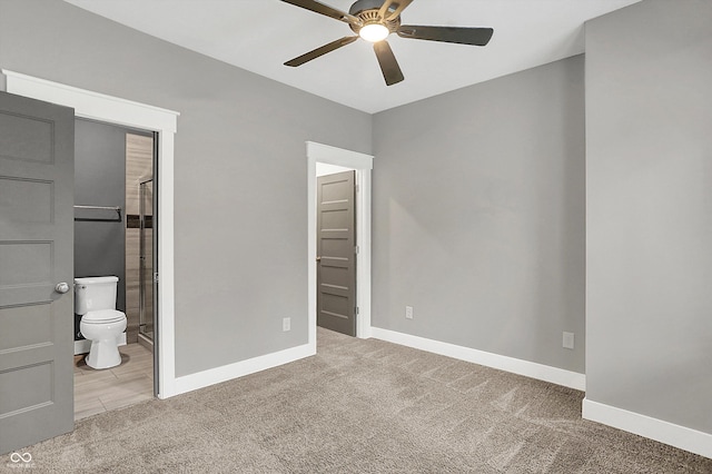 unfurnished bedroom with ceiling fan, ensuite bathroom, and light carpet