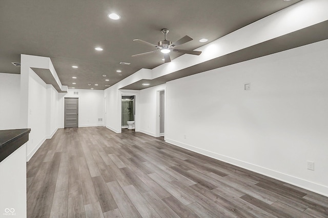 unfurnished living room with ceiling fan and hardwood / wood-style floors