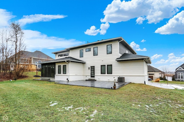 rear view of property featuring a yard, a sunroom, a patio, and central air condition unit