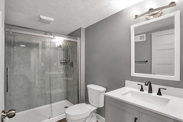 bathroom with vanity, toilet, a textured ceiling, and walk in shower