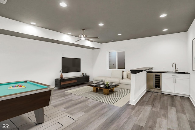 rec room with wine cooler, billiards, wet bar, ceiling fan, and light hardwood / wood-style floors