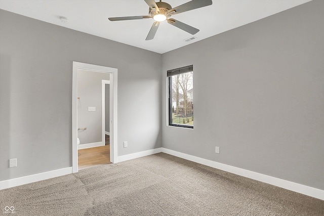 carpeted spare room featuring ceiling fan