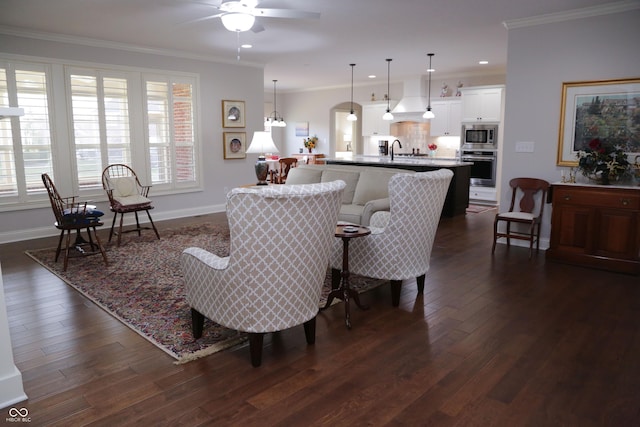 living room featuring ornamental molding, dark hardwood / wood-style floors, sink, and ceiling fan