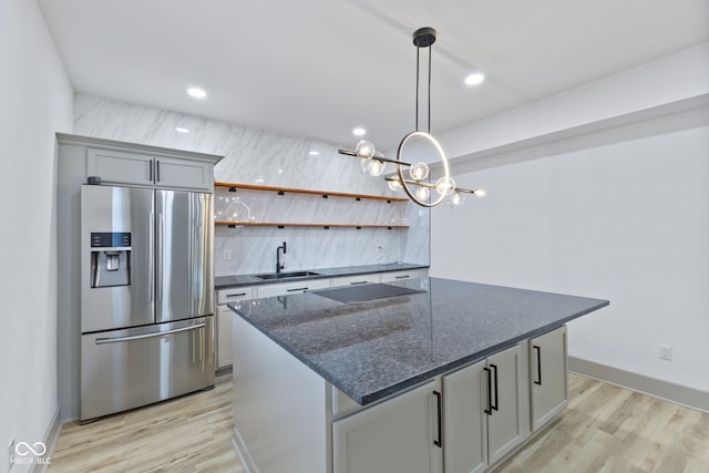 kitchen with sink, gray cabinets, stainless steel refrigerator with ice dispenser, black electric cooktop, and light wood-type flooring