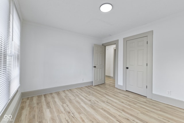 unfurnished room with crown molding and light wood-type flooring