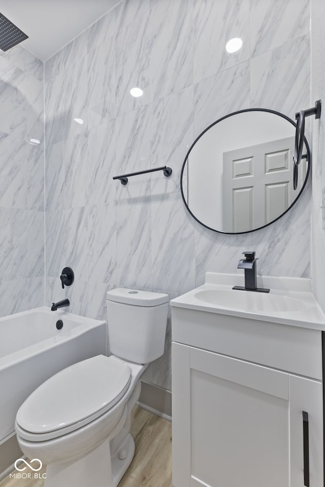 full bathroom with tile walls, vanity, wood-type flooring, shower / bathtub combination, and toilet