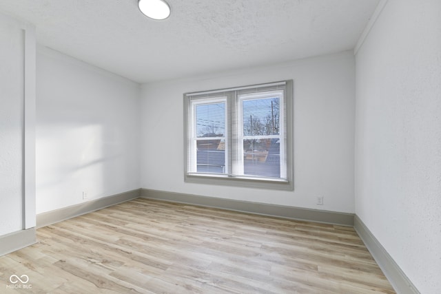 unfurnished room featuring a textured ceiling and light wood-type flooring