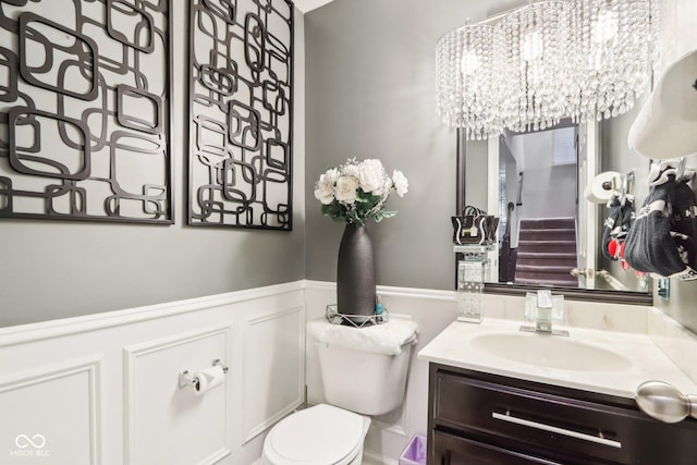 bathroom with an inviting chandelier, vanity, and toilet