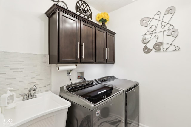 laundry area featuring cabinets, washing machine and clothes dryer, and sink