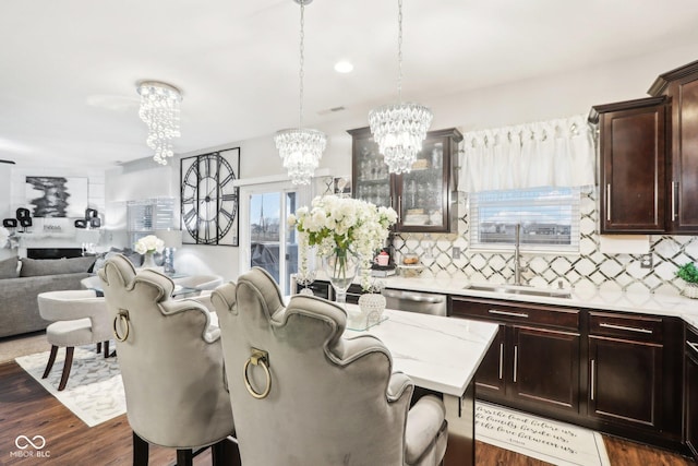 kitchen with sink, dishwasher, a notable chandelier, pendant lighting, and decorative backsplash