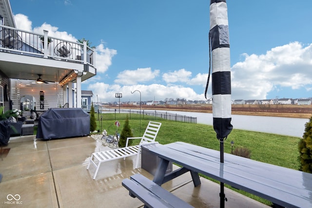 view of patio / terrace with grilling area, a water view, ceiling fan, and a balcony