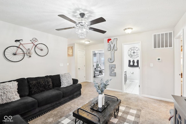 living room with light carpet, a textured ceiling, and ceiling fan