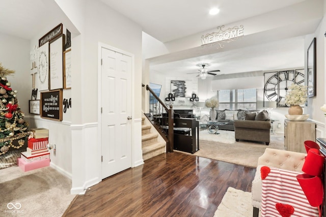 living room with dark hardwood / wood-style flooring and ceiling fan