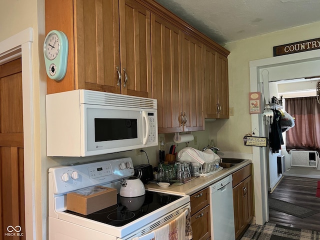 kitchen featuring sink, a wall mounted AC, and white appliances