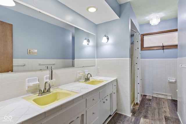 bathroom featuring hardwood / wood-style flooring, vanity, and tile walls