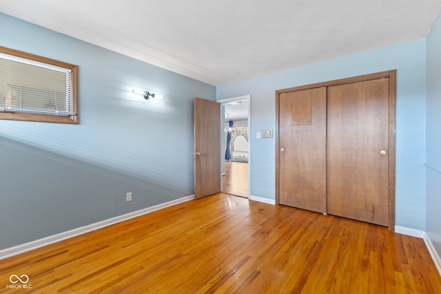 unfurnished bedroom with a closet and light wood-type flooring