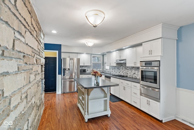 kitchen featuring white cabinetry, tasteful backsplash, dark hardwood / wood-style flooring, a kitchen island, and stainless steel appliances