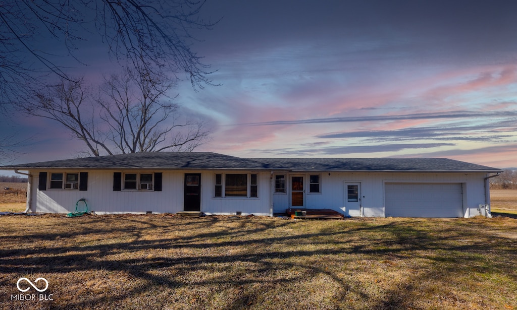 ranch-style house with a garage, driveway, and a front yard