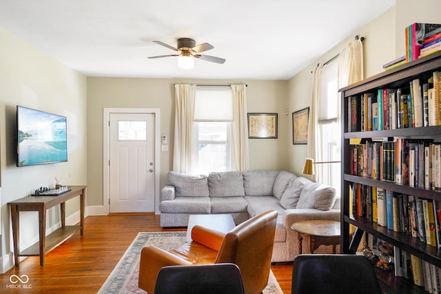 living room featuring wood-type flooring and ceiling fan