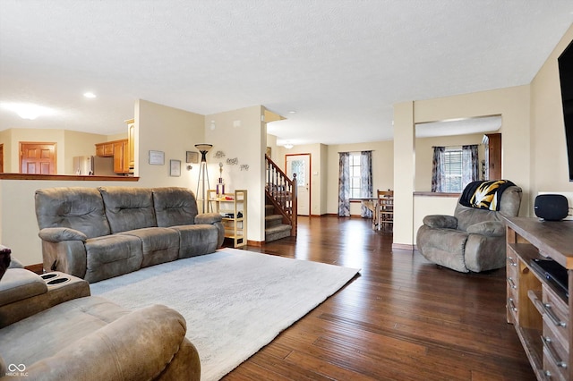 living room with dark wood-type flooring and a textured ceiling