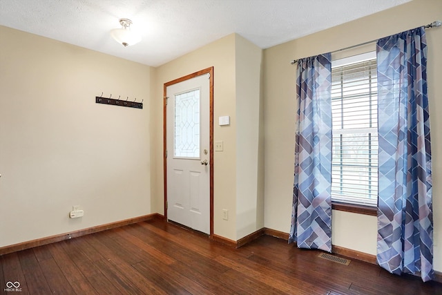 entrance foyer featuring dark hardwood / wood-style flooring and a textured ceiling