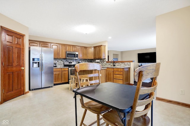 kitchen with stainless steel appliances, sink, and decorative backsplash