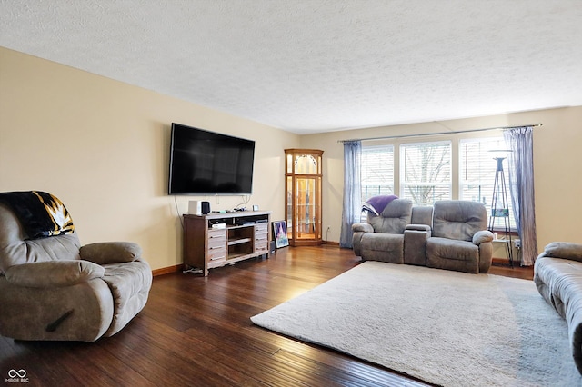 living room featuring dark hardwood / wood-style flooring and a textured ceiling