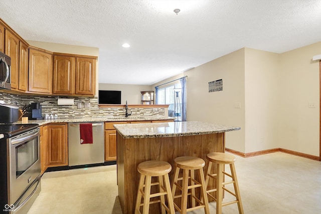 kitchen with stainless steel appliances, a center island, a kitchen breakfast bar, and kitchen peninsula