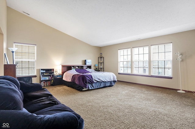 bedroom featuring vaulted ceiling, carpet flooring, and a textured ceiling