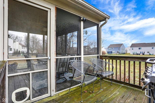 wooden terrace with a sunroom and a lawn