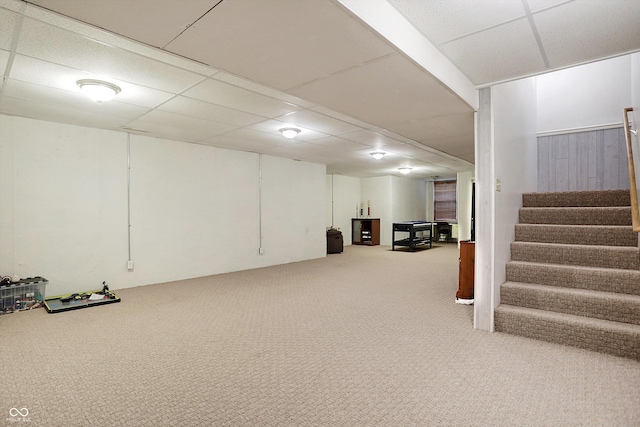 basement with a paneled ceiling and carpet floors