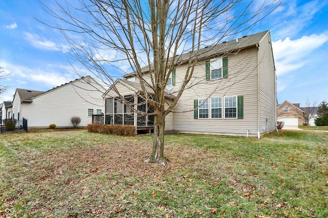 back of house with a yard and a sunroom