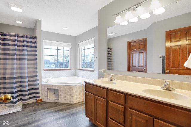 bathroom featuring hardwood / wood-style flooring, vanity, independent shower and bath, and a textured ceiling