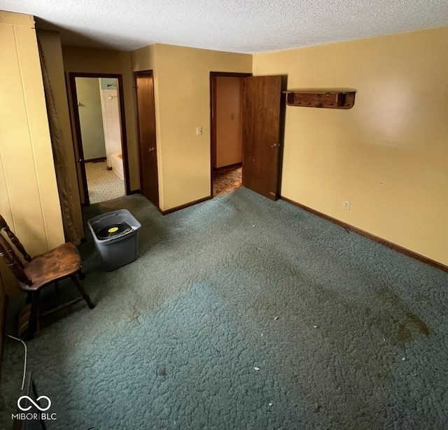 unfurnished bedroom with baseboards, dark colored carpet, and a textured ceiling