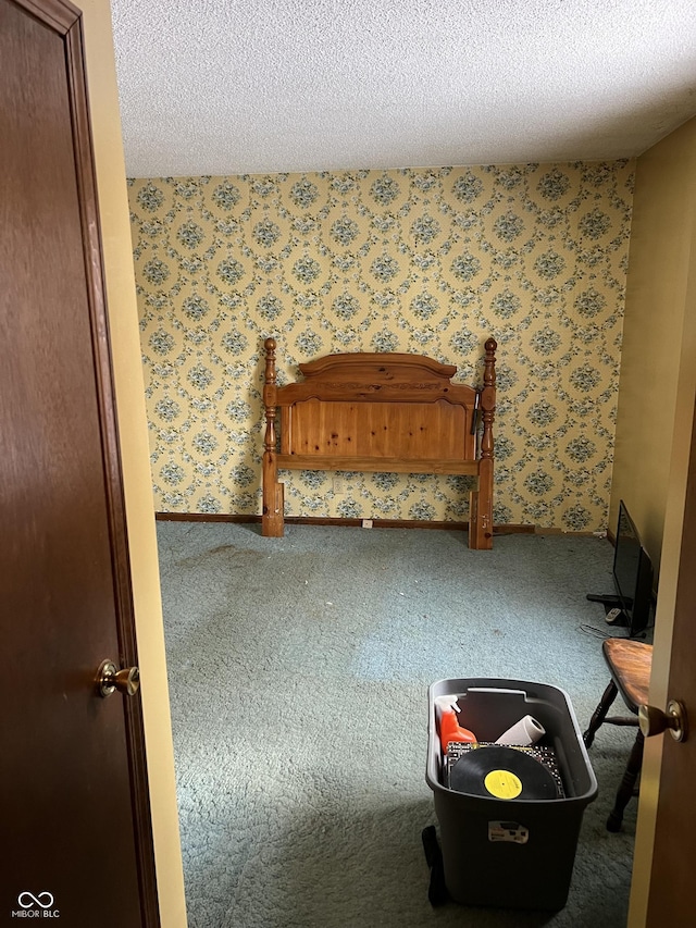 unfurnished bedroom featuring carpet, a textured ceiling, and wallpapered walls