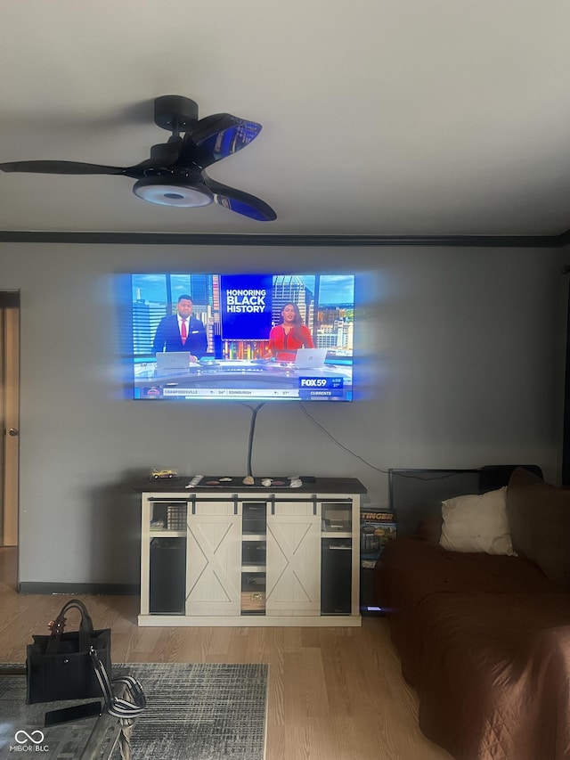 living room featuring ceiling fan, ornamental molding, and wood-type flooring