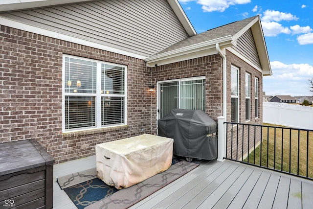 wooden deck with a grill and a lawn