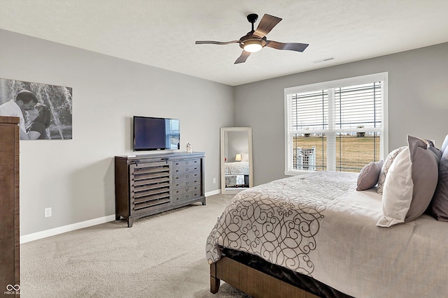 carpeted bedroom with ceiling fan and a textured ceiling