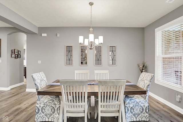 dining space featuring hardwood / wood-style floors and a chandelier