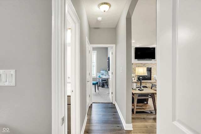 hallway featuring hardwood / wood-style flooring and a textured ceiling