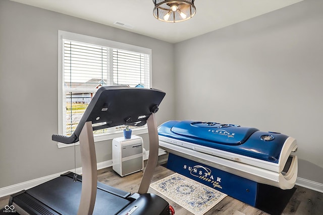 exercise room with hardwood / wood-style floors