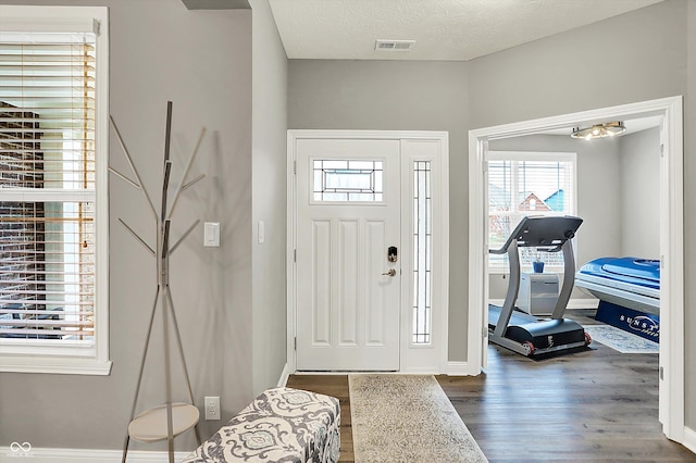 entryway featuring a textured ceiling and dark hardwood / wood-style flooring