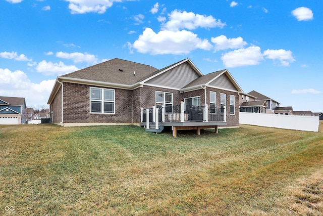 back of property featuring a wooden deck and a lawn