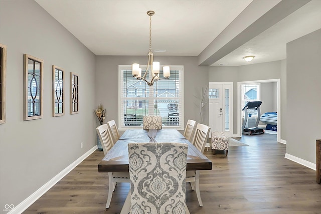 dining room featuring dark hardwood / wood-style flooring and a chandelier