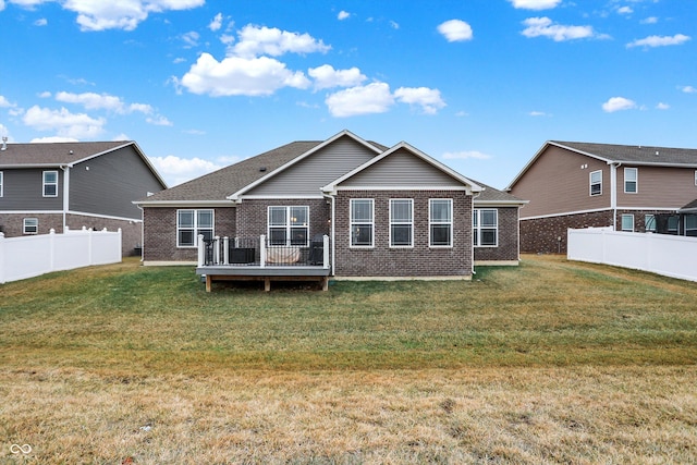 rear view of property featuring a wooden deck and a yard