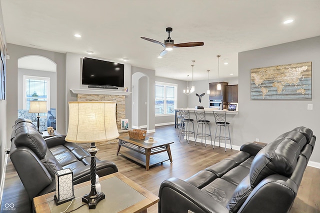 living room with a fireplace, light hardwood / wood-style floors, and ceiling fan