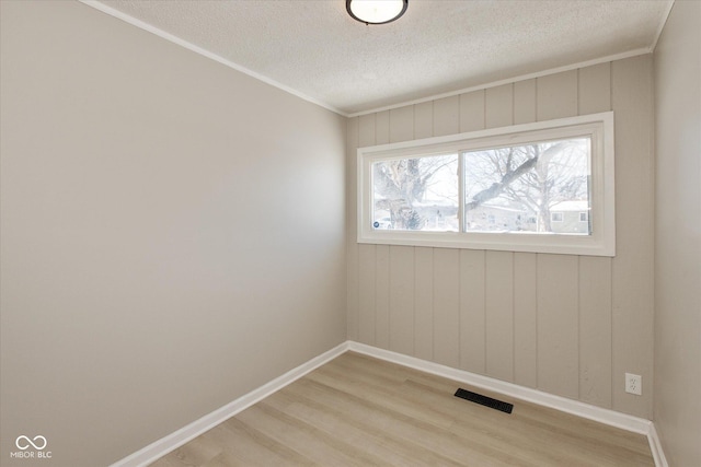 empty room featuring light hardwood / wood-style floors and a textured ceiling