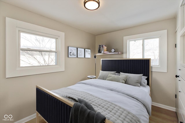 bedroom with hardwood / wood-style flooring and multiple windows